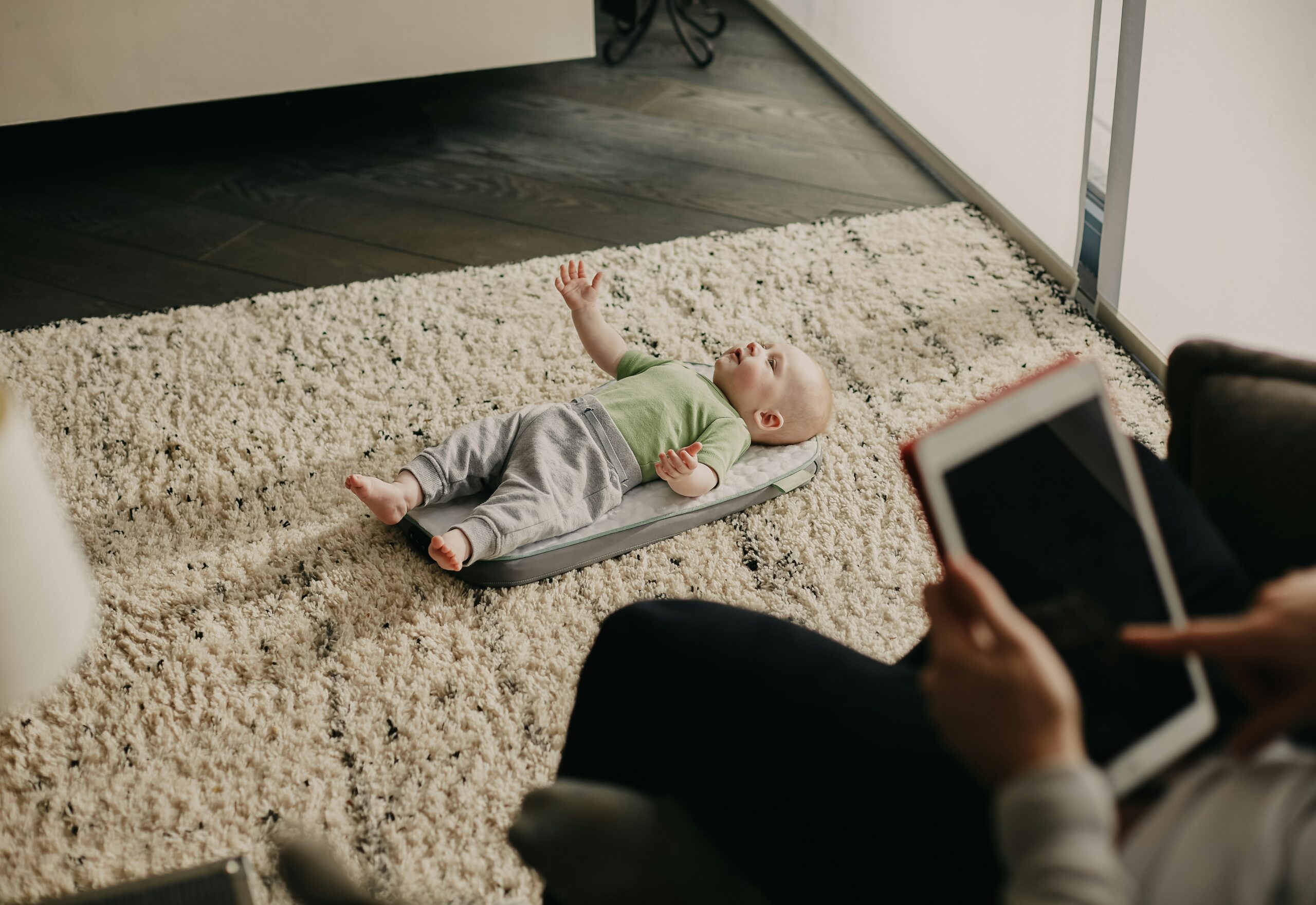 Parent occupé à regarder les écrans alors qu'il garde son bébé